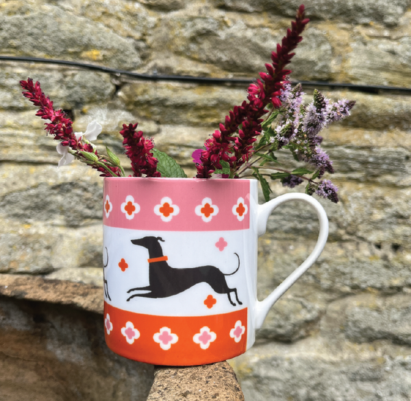 Fine bone china mug depicting three dogs running with an orange and pink border at the top and bottom
