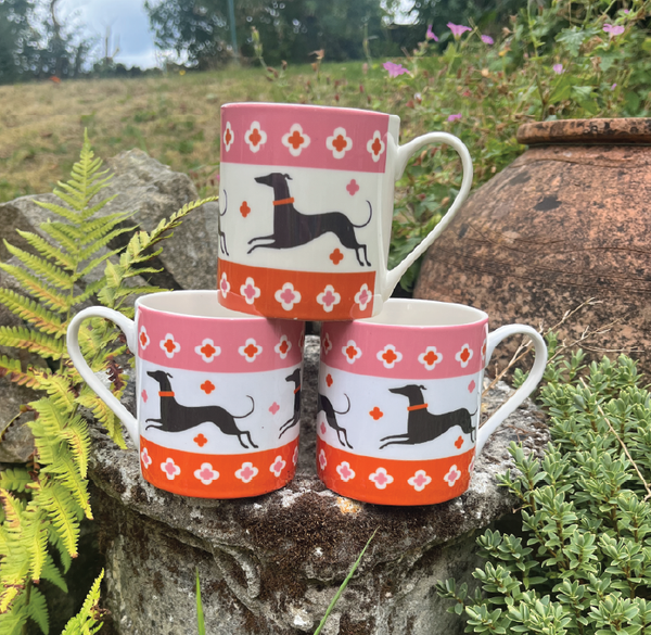 Fine bone china mug depicting three dogs running with an orange and pink border at the top and bottom