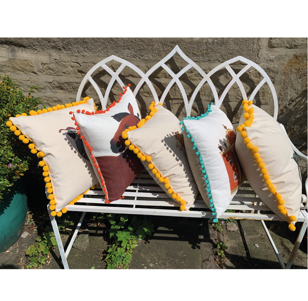 Folly Cushion with blue pom poms